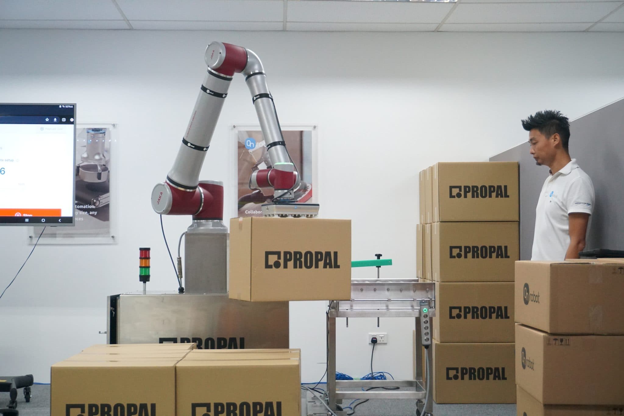 Robotic palletiser by OnRobot and ProPal Robotics lifting a box, automating palletising in Singapore.