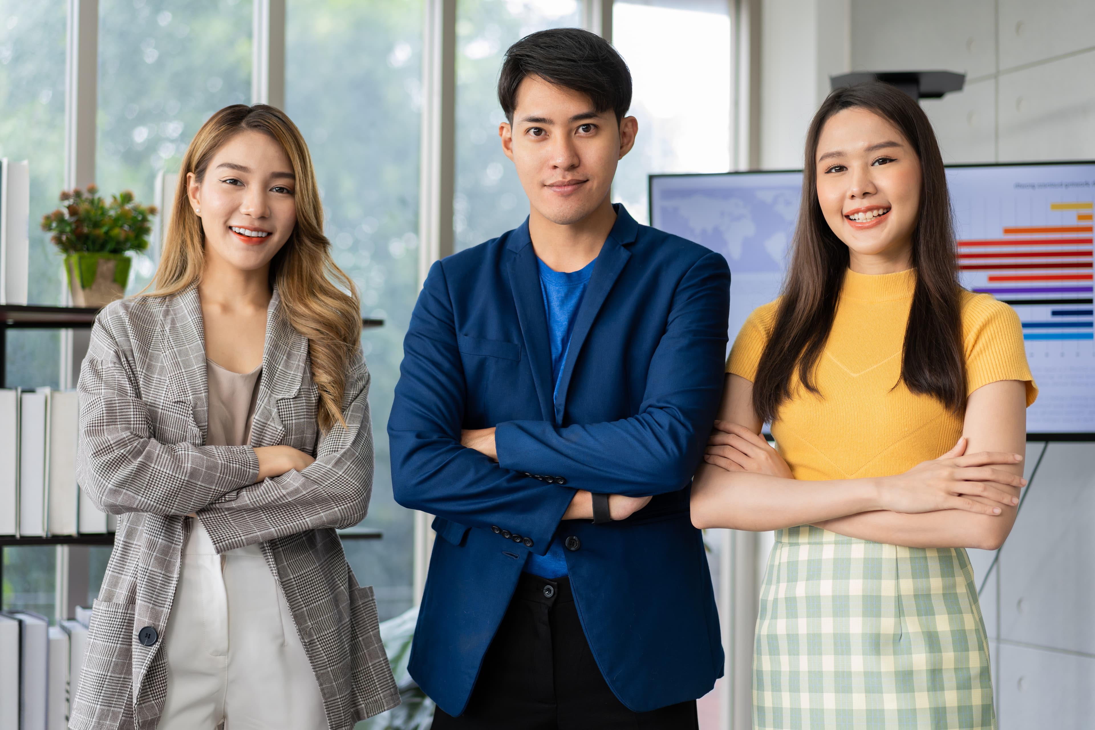 Three young Asian professionals in modern office environment